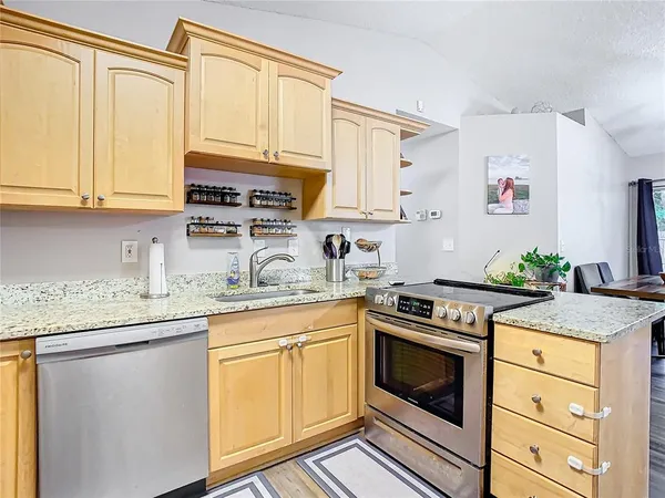 a kitchen with stainless steel appliances granite countertop a stove a sink and a microwave
