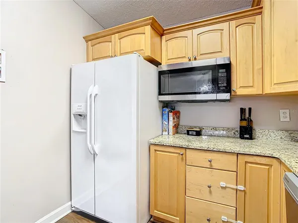 a kitchen with stainless steel appliances granite countertop a refrigerator sink and microwave