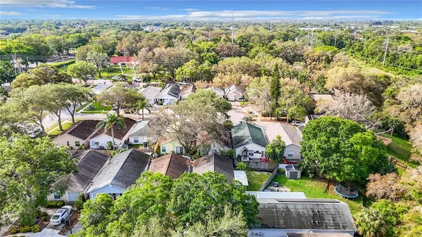 an aerial view of residential houses with outdoor space and trees