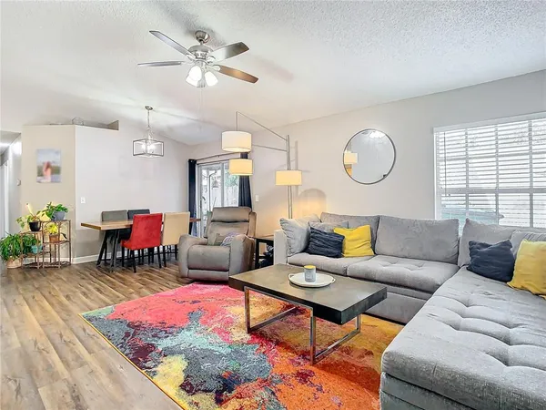 a living room with furniture a chandelier and a large window