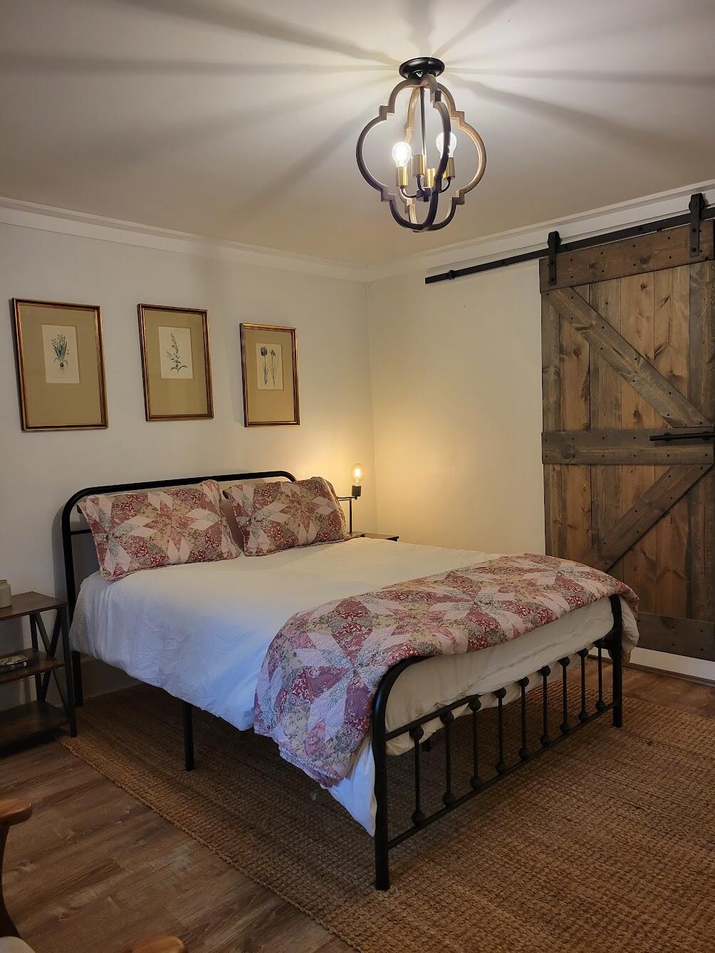3542 Persimmon Road Shawsville, VA 24162 - Photo 36 of 94 a bedroom with a bed lamp and paintings on the wall