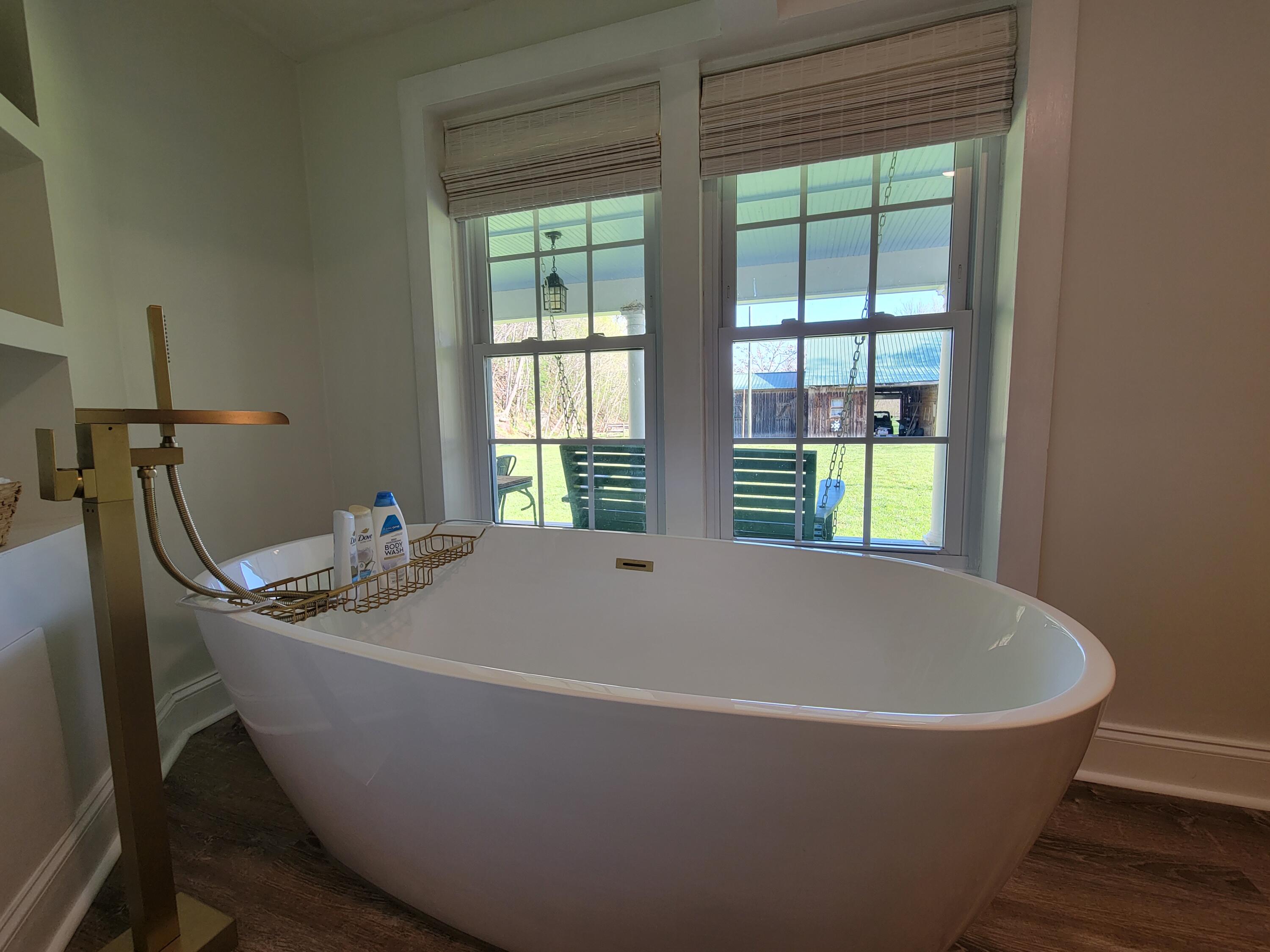 3542 Persimmon Road Shawsville, VA 24162 - Photo 41 of 94 a white bath tub sitting in a bathroom next to a window
