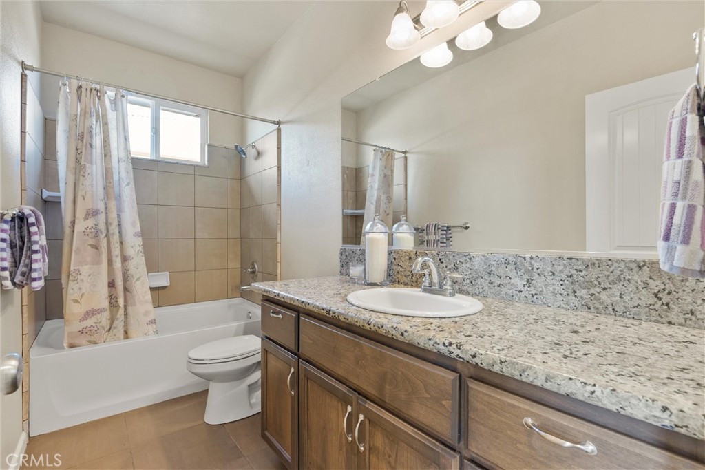 320 Sonora Lane Chico, CA 95973 - Photo 11 of 21 a bathroom with a granite countertop sink a toilet a mirror and bathtub
