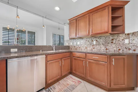 a kitchen with stainless steel appliances granite countertop a sink stove and cabinets