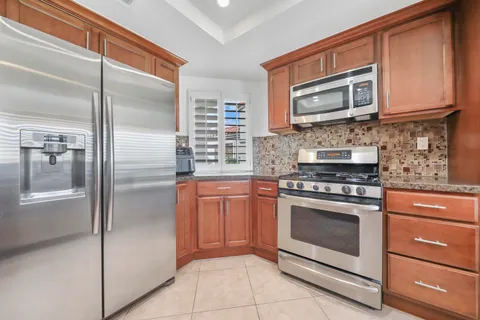 a kitchen with stainless steel appliances granite countertop a refrigerator stove and oven