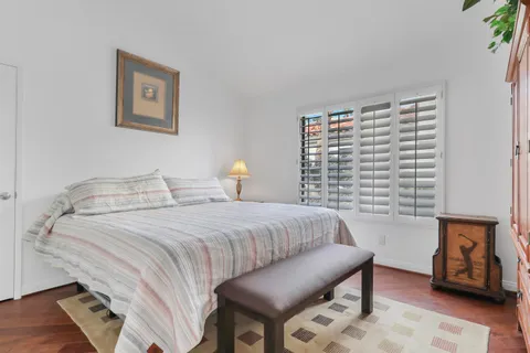 a bedroom with a bed a couch and painting on the wall