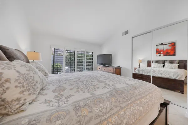 a bedroom with a bed and a flat screen tv