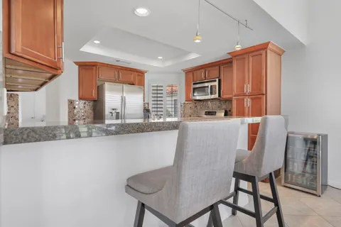 a kitchen with stainless steel appliances granite countertop a sink and a refrigerator