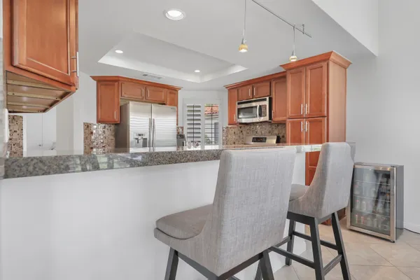 a kitchen with stainless steel appliances granite countertop a sink and a refrigerator
