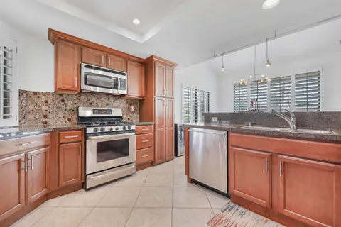 a kitchen with stainless steel appliances granite countertop a stove sink and microwave