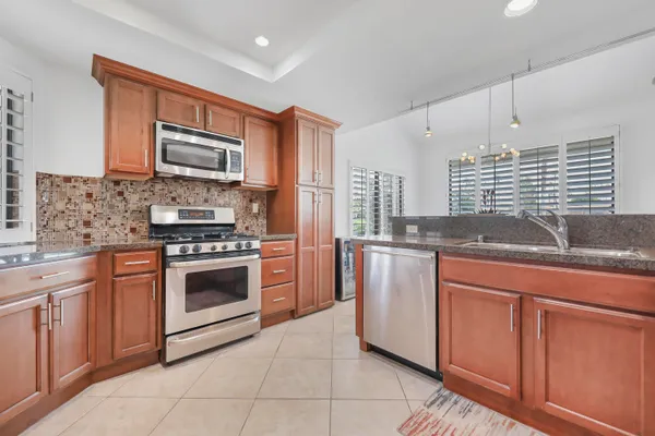 a kitchen with stainless steel appliances granite countertop a stove sink and microwave