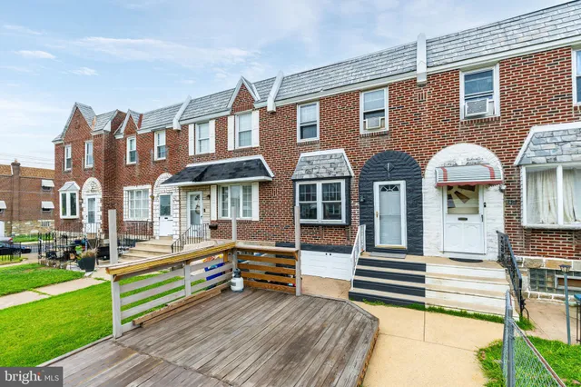 a front view of multiple houses with yard