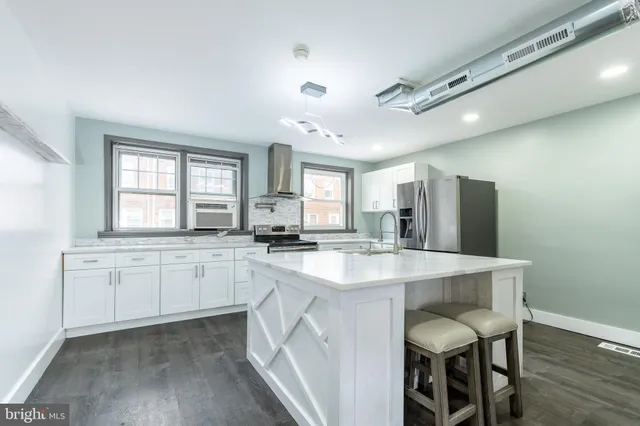 a kitchen with stainless steel appliances granite countertop a white cabinets and a refrigerator