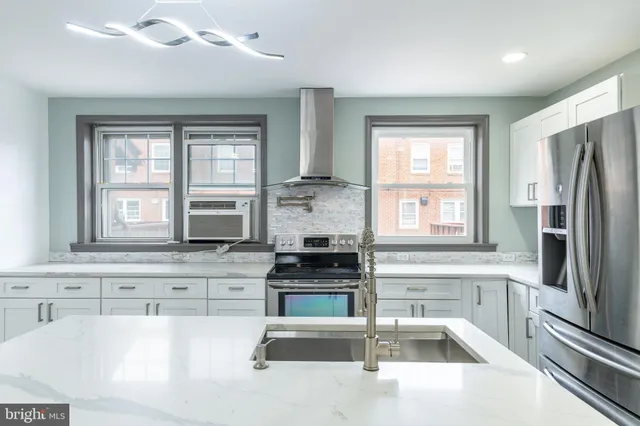 a kitchen with granite countertop a refrigerator and a sink