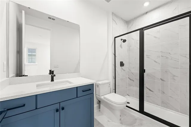 a bathroom with a toilet a sink a mirror and a shower