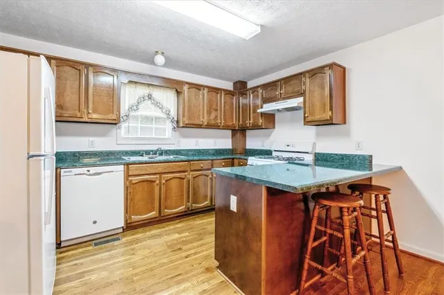 a kitchen with granite countertop a sink and a stove