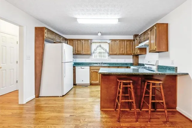 a kitchen with stainless steel appliances granite countertop a refrigerator and a stove top oven