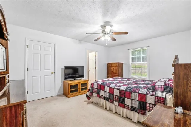 a bedroom with a bed a chandelier and dresser