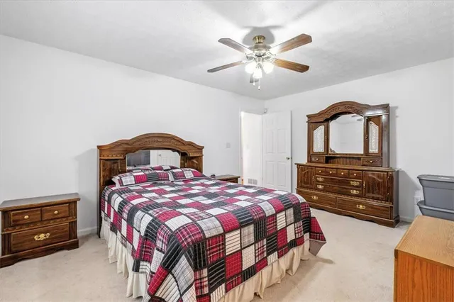 a bedroom with a bed a chandelier and dresser