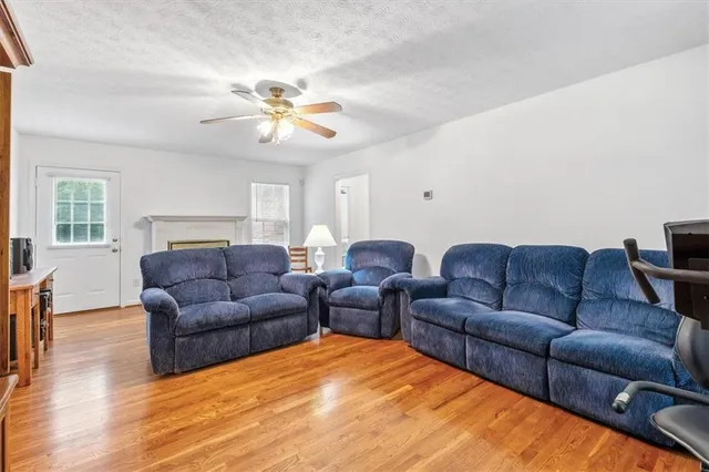 a living room with furniture ceiling fan and a wooden floor
