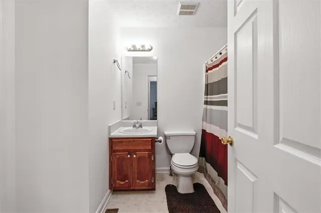 a white toilet sitting next to a bathroom sink and vanity