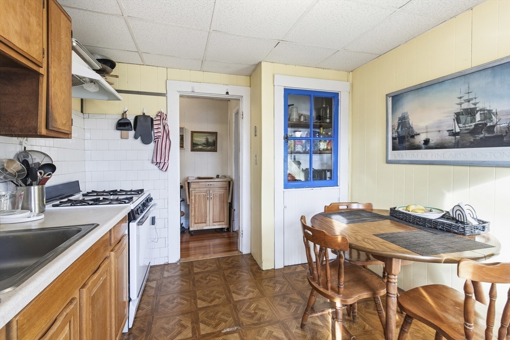 78 R Mt Vernon Street Somerville, MA 02145 - Photo 12 of 32 a kitchen with stainless steel appliances kitchen island a table and chairs in it