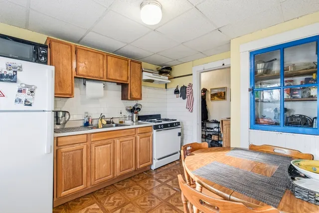 a kitchen with granite countertop white cabinets and white appliances