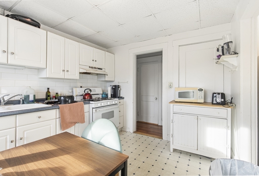 78 R Mt Vernon Street Somerville, MA 02145 - Photo 18 of 32 a kitchen with granite countertop white cabinets and white appliances