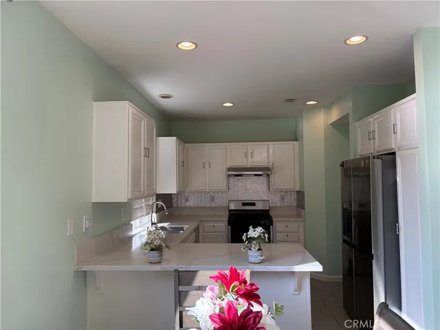 a kitchen with stainless steel appliances a refrigerator sink and cabinets