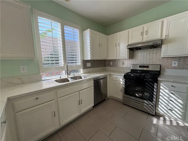 a kitchen with stainless steel appliances granite countertop a sink a stove a microwave a center island and cabinets