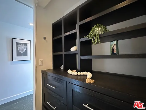 a hallway with a potted plant on a table and a potted plant