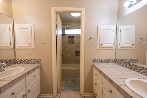 a bathroom with a granite countertop sink a mirror and a shower