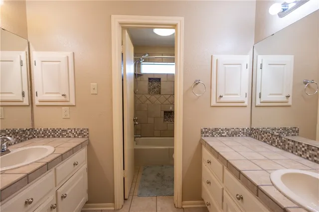 a bathroom with a granite countertop sink a mirror and a shower