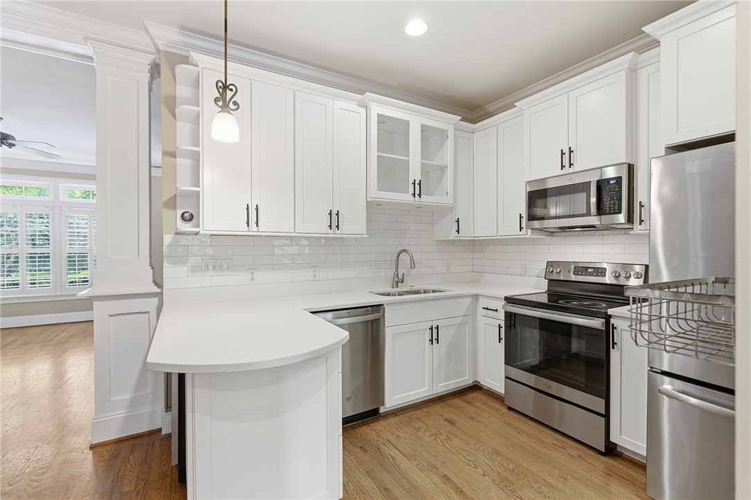 204 Butler Avenue Greenville, SC 29601 - Photo 12 of 26 Gleaming white cabinetry and stainless appliances create a bright and functional kitchen space.