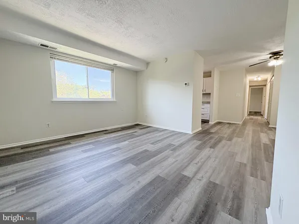 an empty room with wooden floor and a window