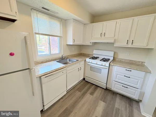 a kitchen with white cabinets and white appliances