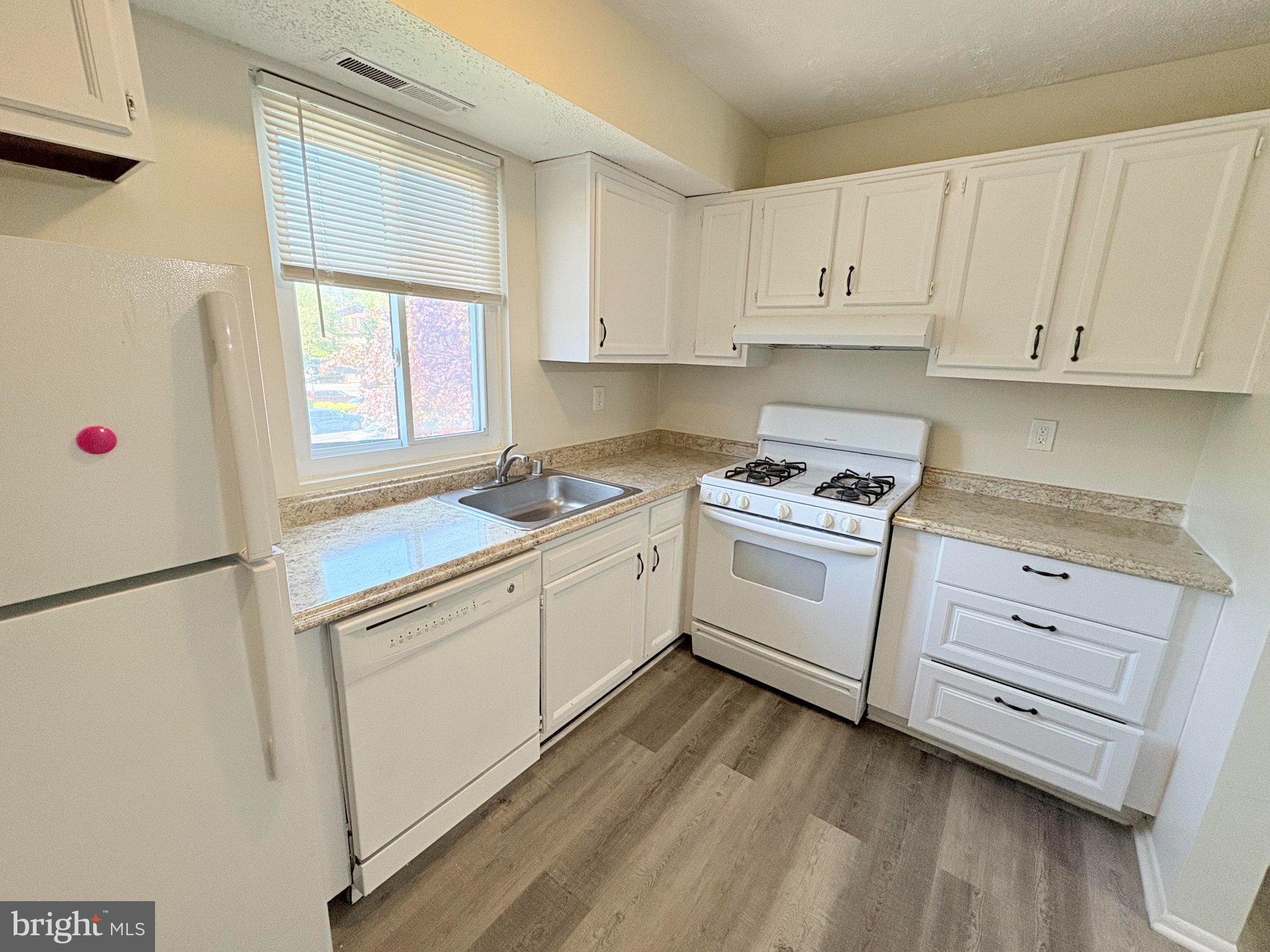 11905 I Tarragon Road, Unit I Reisterstown, MD 21136 - Photo 5 of 13 a kitchen with white cabinets and white appliances