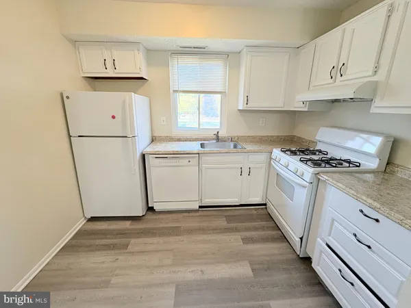 a kitchen with white cabinets sink and white appliances