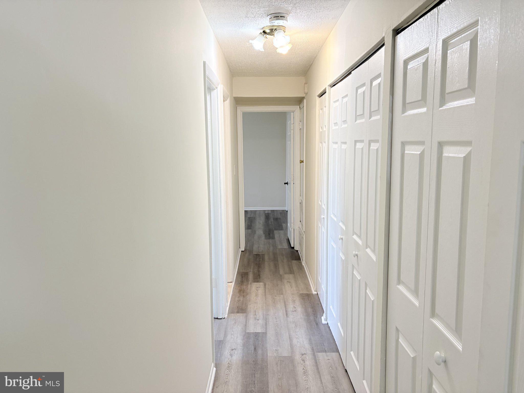 11905 I Tarragon Road, Unit I Reisterstown, MD 21136 - Photo 7 of 13 a view of a hallway with wooden floor and a bathroom