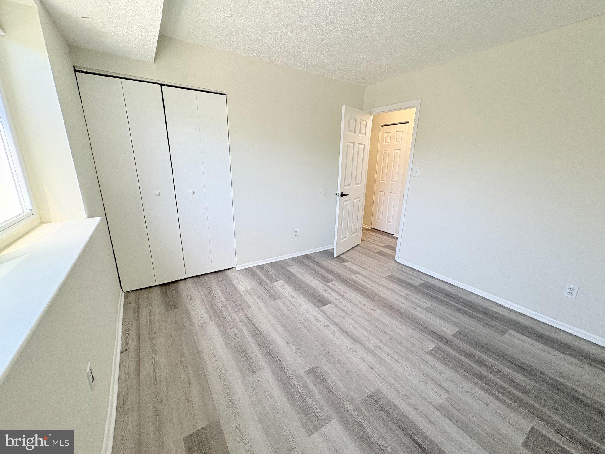 11905 I Tarragon Road, Unit I Reisterstown, MD 21136 - Photo 9 of 13 a view of an empty room with wooden floor and a window