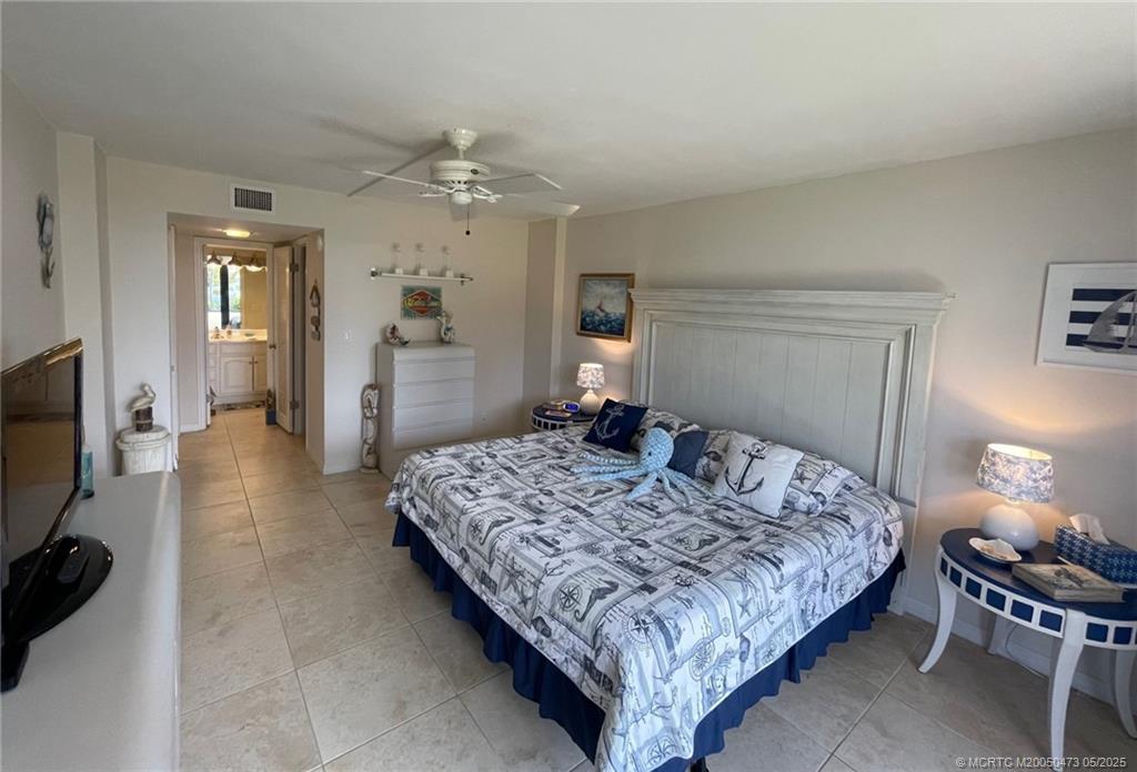1357 Northeast Ocean Boulevard, Unit 106 Stuart, FL 34996 - Photo 17 of 38 a bedroom with a bed and a dresser in it