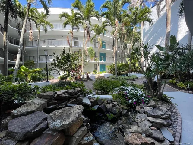 a view of backyard of multi story residential apartment building with yard and outdoor seating