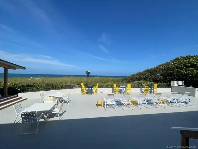 a view of a patio with dining table and chairs under an umbrella