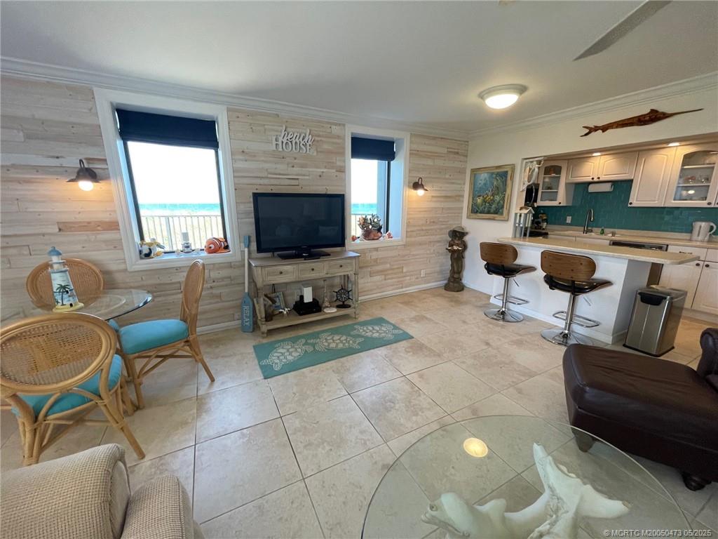 1357 Northeast Ocean Boulevard, Unit 106 Stuart, FL 34996 - Photo 10 of 38 a living room with furniture and a flat screen tv