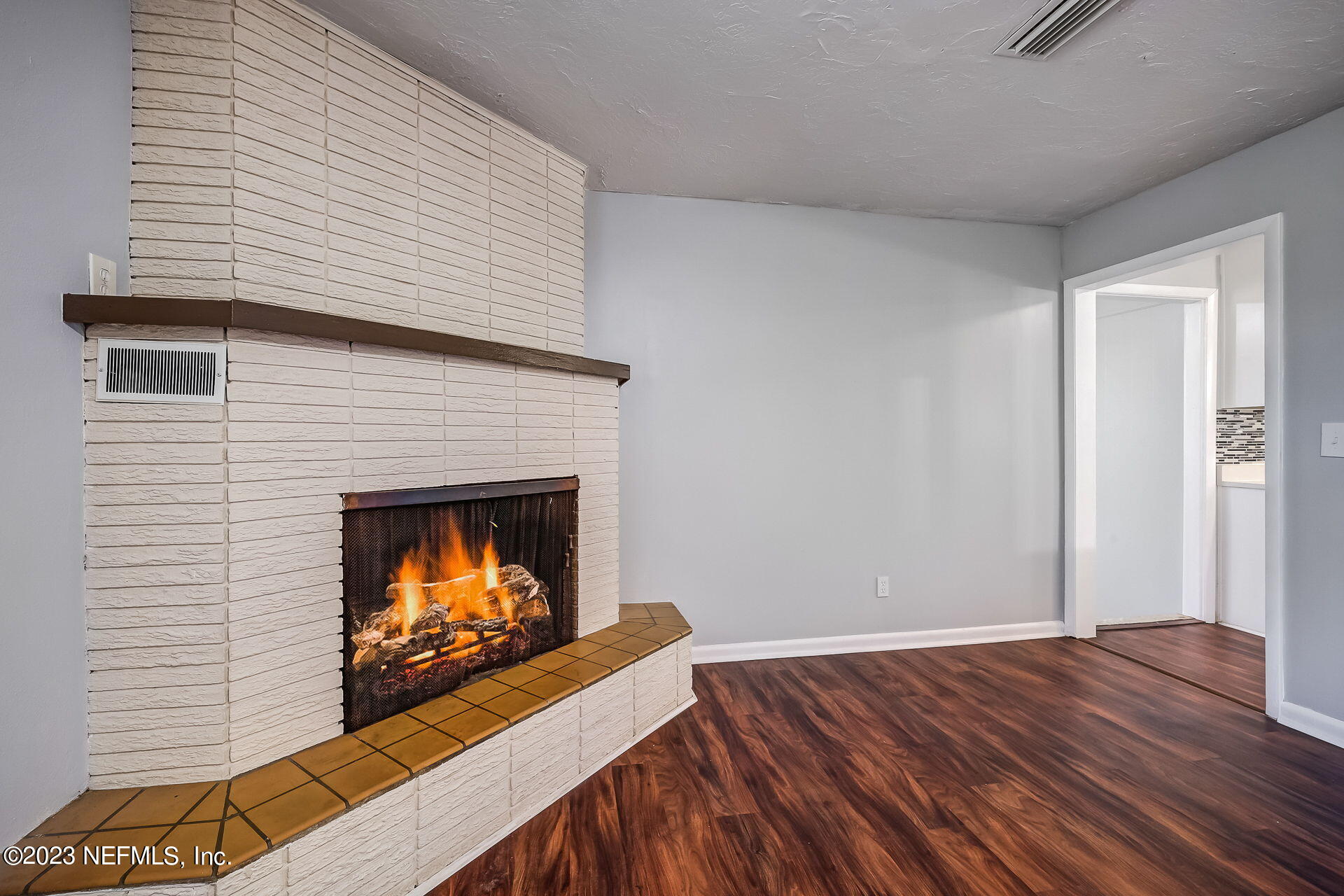 3546 Clyde Drive Jacksonville, FL 32208 - Photo 15 of 50 a view of an empty room with wooden floor fireplace and a window