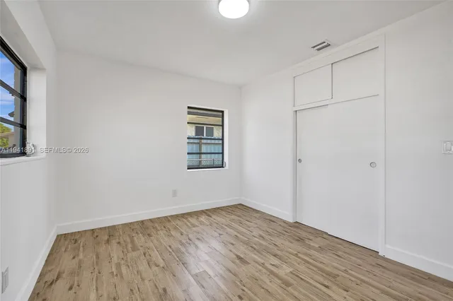 an empty room with wooden floor and closet