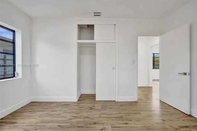 a view of empty room with wooden floor