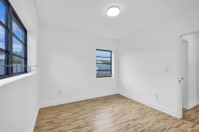 a view of empty room with wooden floor