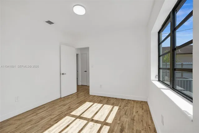 wooden floor in an empty room with a window
