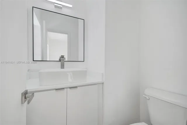 a bathroom with a sink and mirror with toilet